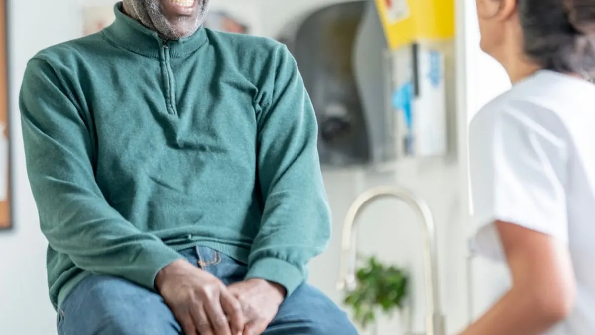 A patient in conversation with a community nurse in a clinic room